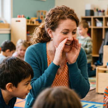 A teacher cups her hands around her mouth and whispers a sound to a delighted group of students sitting on a classroom rug, with a girl across from her laughing in anticipation during a playful phonological awareness activity.