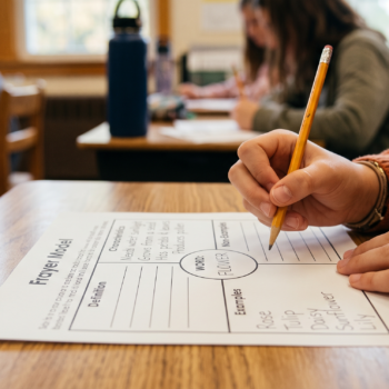A student fills in the examples section of a Frayer Model vocabulary worksheet for the word "flower."