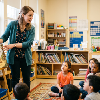 Teacher holding up a picture book during a whole language read-aloud with students seated on a classroom rug